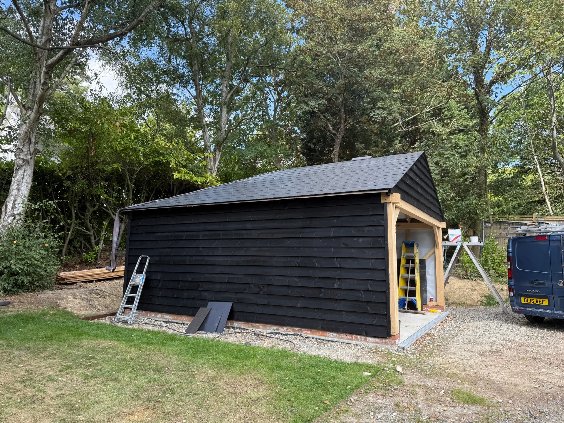 Black garden room with pitched artificial slate roof