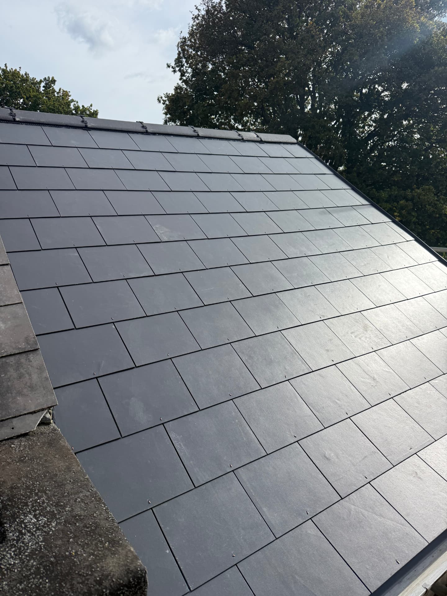 Newly installed artificial slate roof with a neat, uniform finish